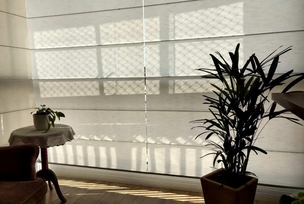 Ambiente integrado em Campo Bom com persiana romana sob medida filtrando a luz da tarde